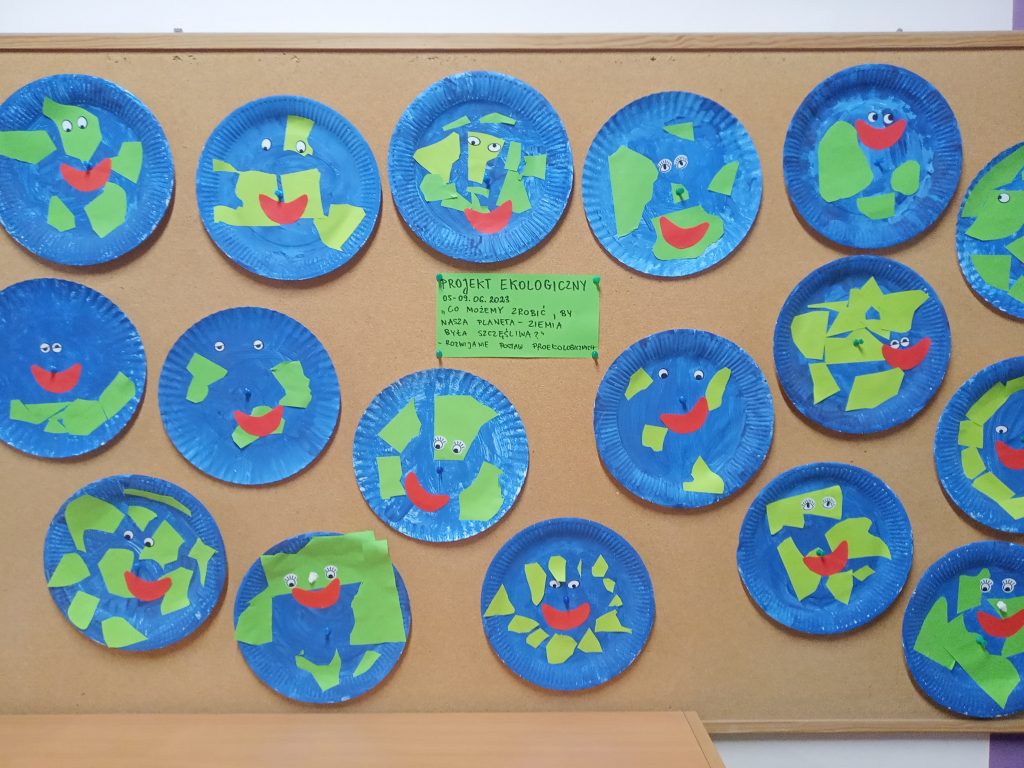 Na obrazku jest tablica z pracami dzieci - uśmiechnięta planeta Ziemia